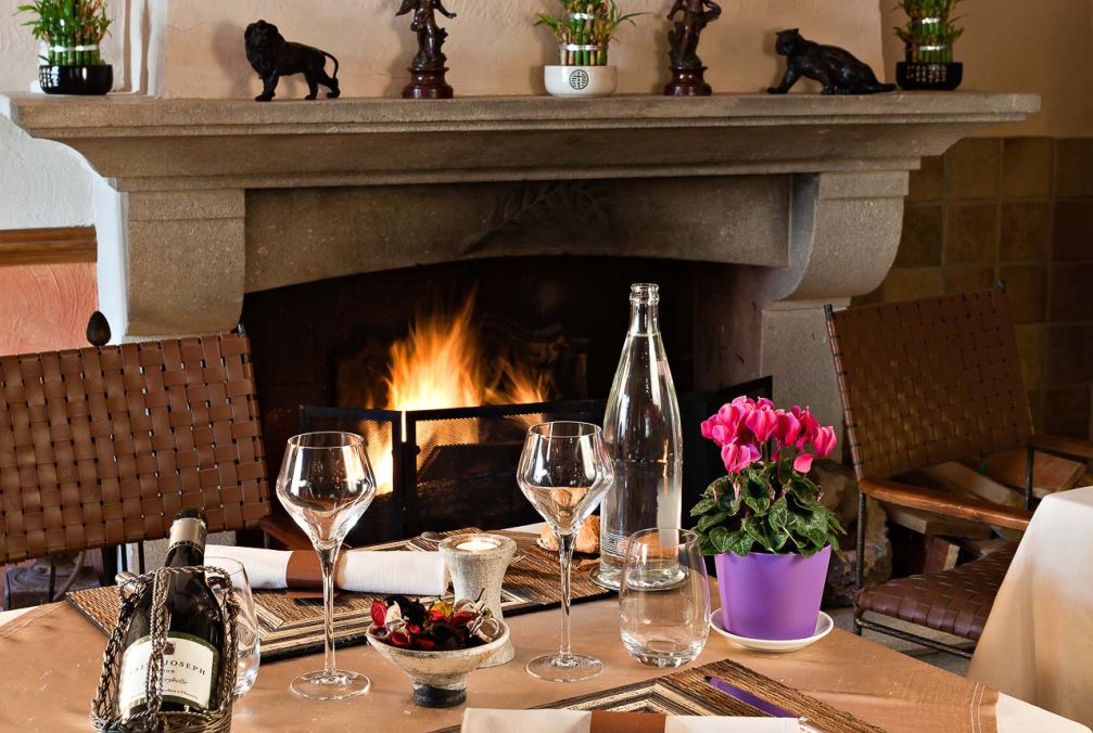 Restaurant table by the fireplace at Domaine du Val de Sault